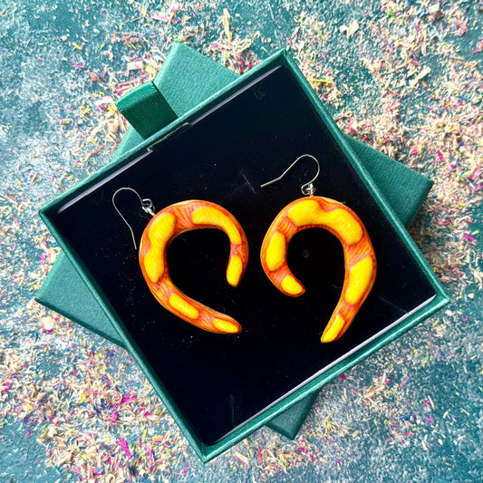Heart-shaped earrings in a green box on a colorful background