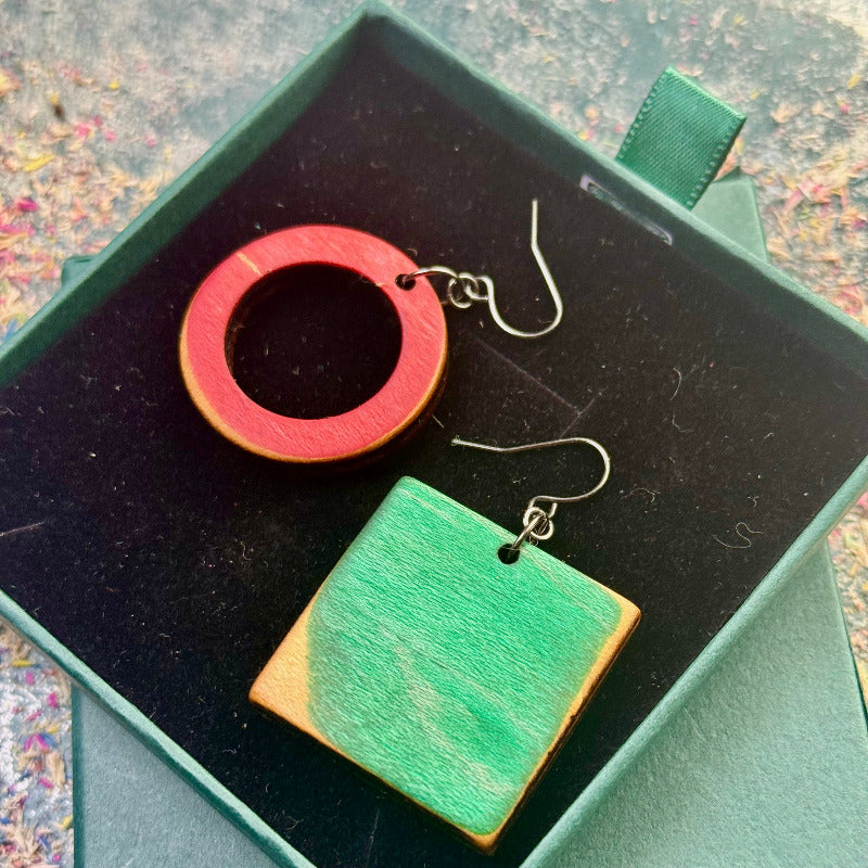 Wooden earrings in a green box with a colorful background