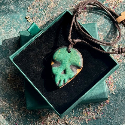 Green and brown pendant on a string in a green box