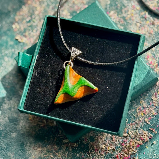 Triangular pendant with green and orange design on a silver chain, displayed in a green box.