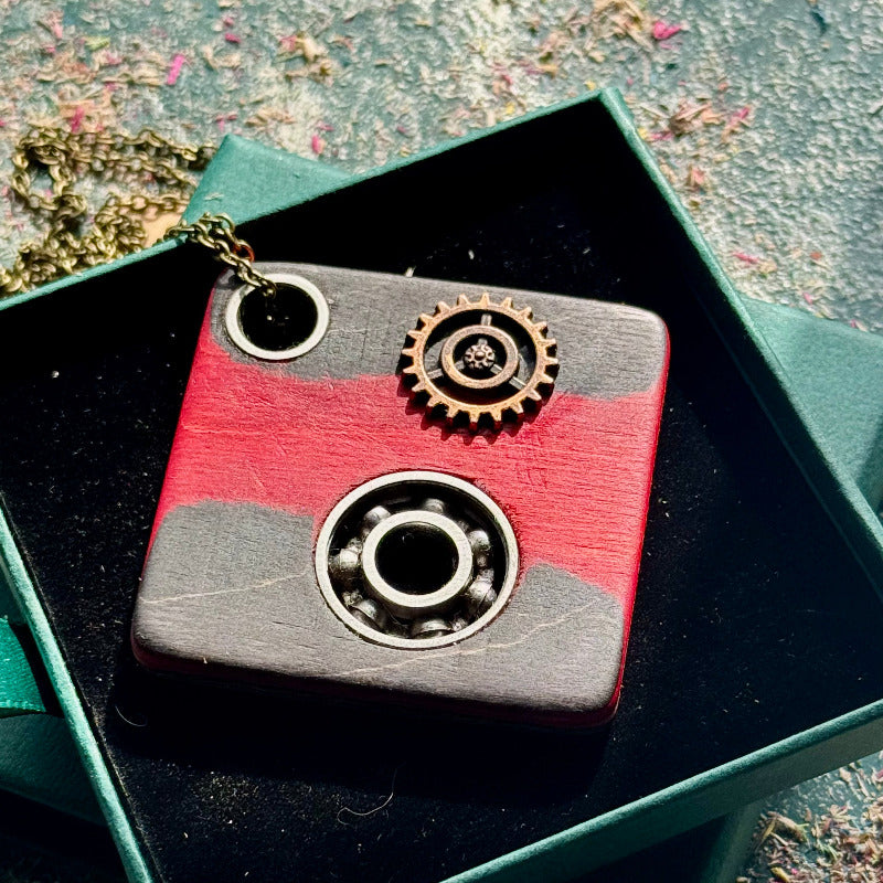 A black, pink and grey pendant made from recycled skateboard wood with oiled wooden finish, handmade by Baltic Dew