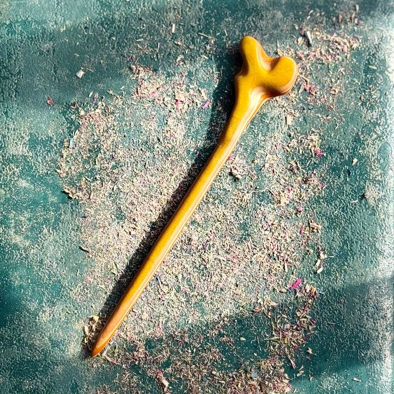 Yellow and orange skateboard maple hair stick with a shaped top.