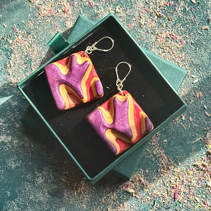 A black, pink and grey ring made from recycled skateboard wood with glossy CA glue finish, handmade by Baltic Dew