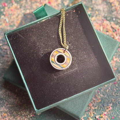 Necklace with a decorative pendant in a green box on a textured surface