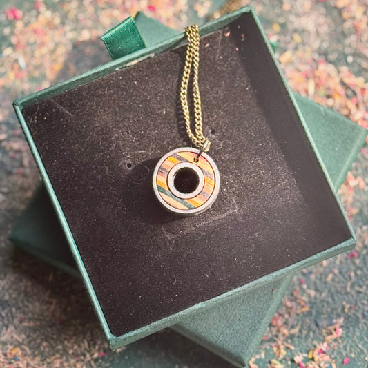 Necklace with a decorative pendant in a green box on a textured surface