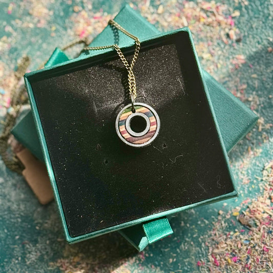 Necklace with a pendant on a black square in a green jewelry box.
