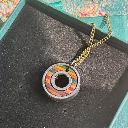 Necklace with a colorful pendant on a black surface