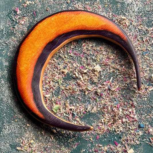 A multicolour layered jewellery piece made from recycled skateboard wood, handmade by Baltic Dew Crafted from recycled.