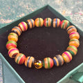 Skateboard bracelet with rounded maple beads and one Baltic amber bead.