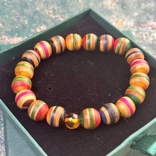 Skateboard bracelet with rounded maple beads and one Baltic amber bead.