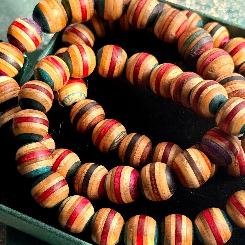Round skateboard maple beads with multicoloured layered stripes.