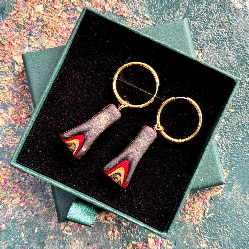 Recycled skateboard hoop earrings with red and black layered maple drops on gold stainless steel hoops.