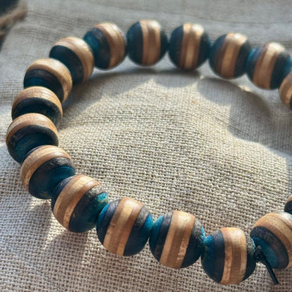 A grey and black bracelet made from recycled skateboard wood with oiled wooden finish, handmade by Baltic Dew