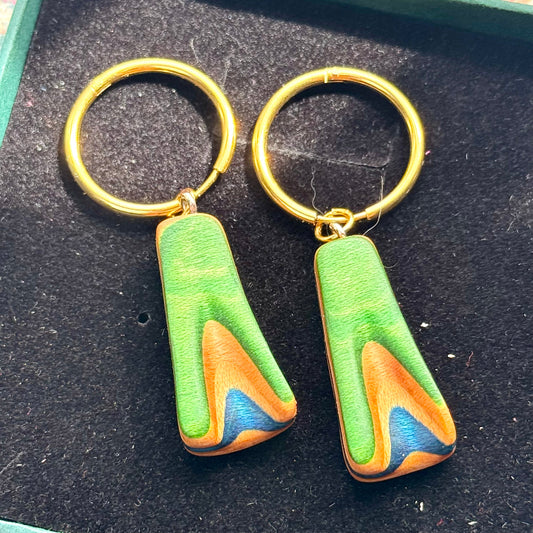 Green and blue recycled skateboard hoop earrings with visible maple layers.