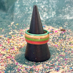 Orange, red and green skateboard maple ring on a black holder, seen from the side.
