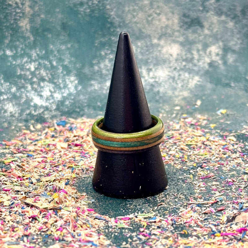 Slim green, purple and teal skateboard maple ring on a black ring holder.