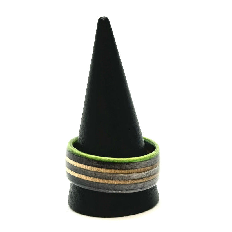 Handmade recycled skateboard ring with stacked grey and natural maple layers, framed by a bright green edge. Glossy finish and sustainable design.