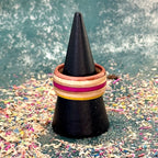 Yellow and pink skateboard maple ring seen from above on a black cone.