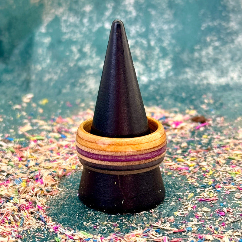 Purple and black skateboard maple ring on a black ring holder.