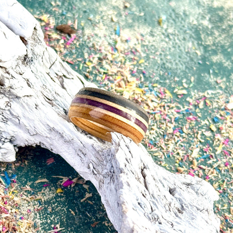 Purple and black skateboard maple ring on a textured background, handmade by Baltic Dew.