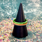 Slim skateboard maple ring with green and blue edges, on a black ring holder.