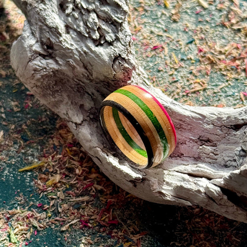 Skateboard maple ring with visible pink, green, black and natural layers.