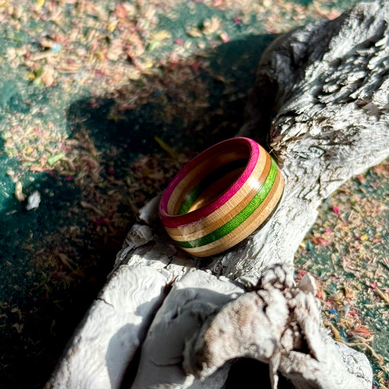 Pink, green and black skateboard maple ring on driftwood, handmade by Baltic Dew.