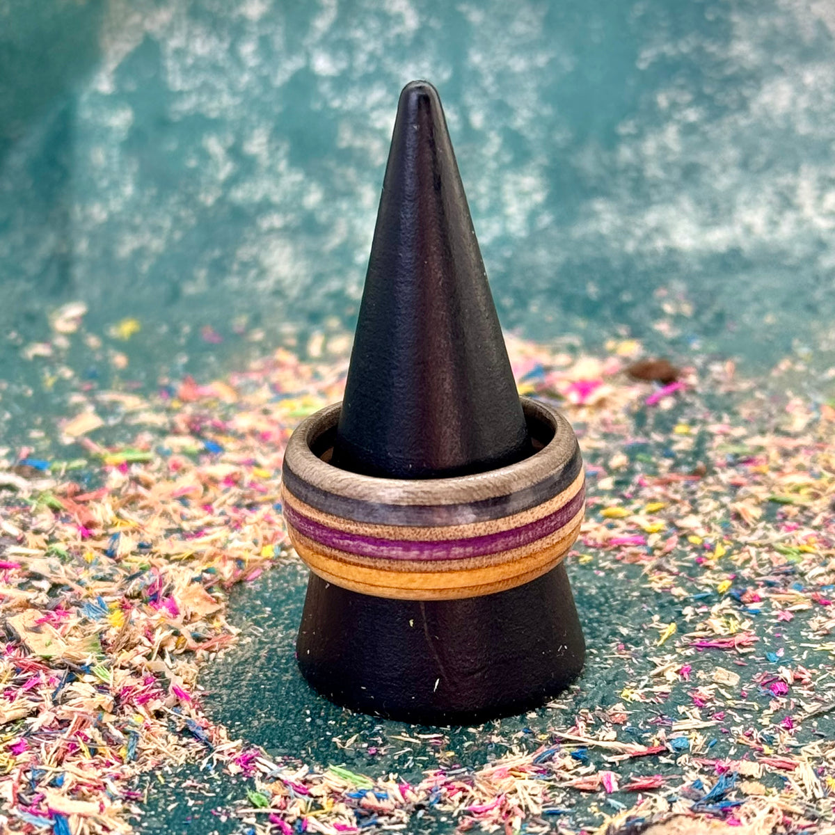 Purple and black skateboard maple ring on a black holder, stripes running round the band.