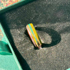Green, purple and teal layers running through a slim skateboard maple band.
