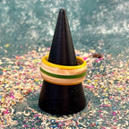 Yellow and green skateboard maple ring on a black cone stand.