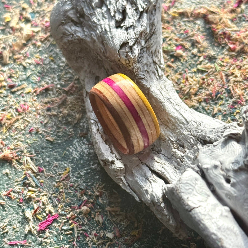 Close-up of the yellow, pink and natural maple layers in a skateboard wood ring.