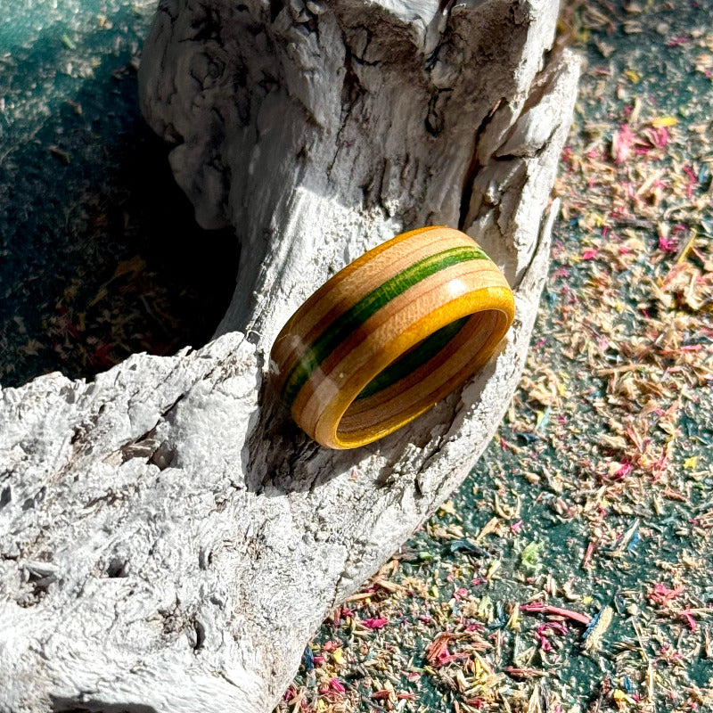 Yellow and green skateboard maple ring resting on driftwood.