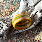 Yellow and green skateboard maple ring on a textured background, layers visible round the band.