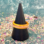 Slim yellow and orange skateboard maple ring on a black ring holder.